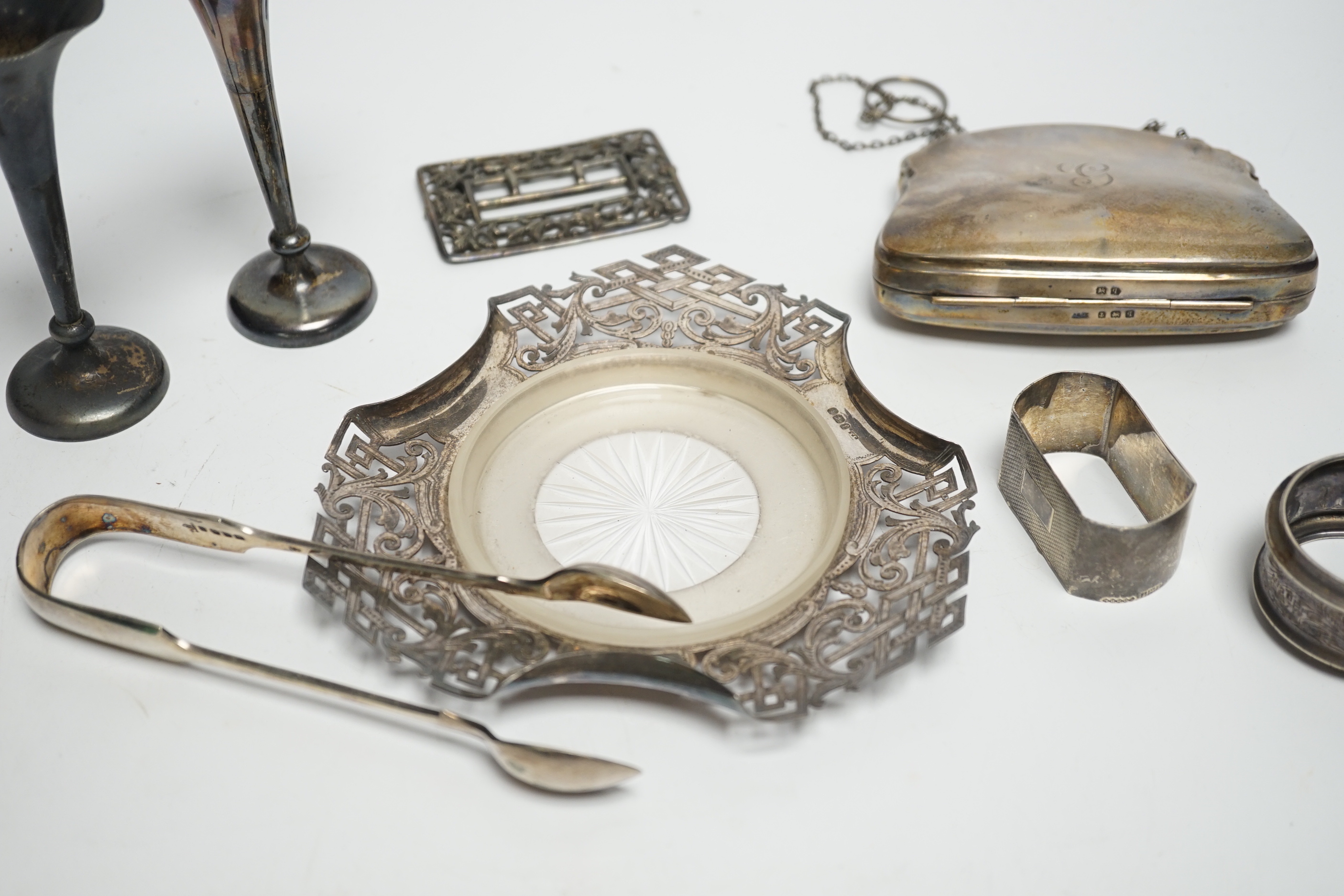 A pair of Edwardian silver mounted posy vases, Birmingham, 1902, weighted, 11.1cm, a silver purse, two silver napkin rings, silver butter dish stand, a silver belt buckle and a pair of plated sugar tongs.